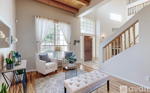 A living room with a white couch and a glass coffee table.
