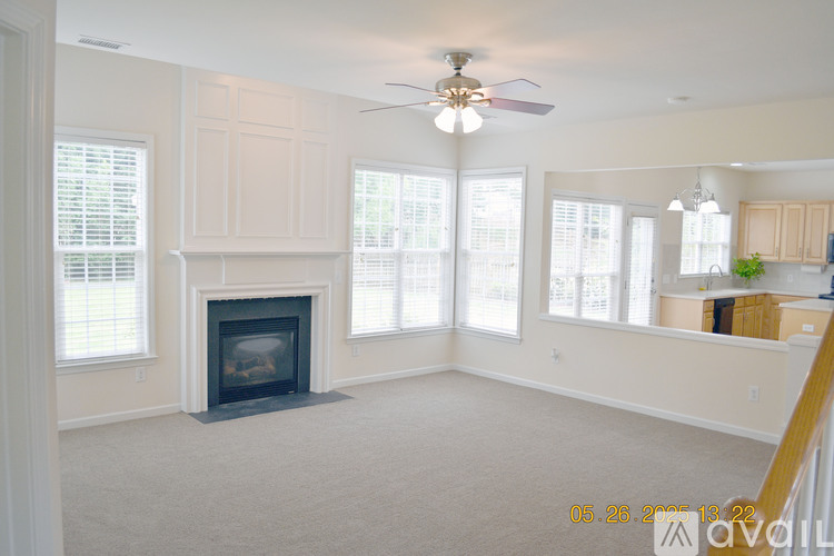 A living room with a fireplace and a ceiling fan.