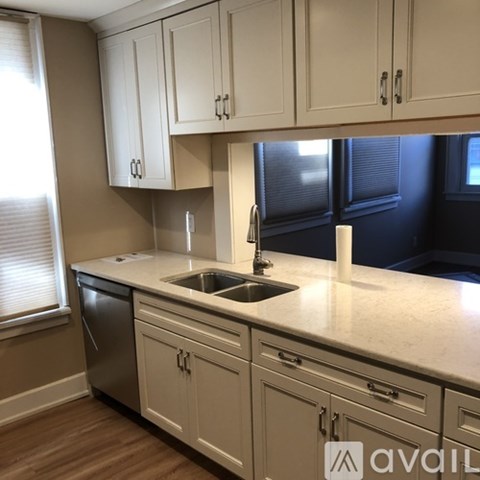 A kitchen with white cabinets and a sink.