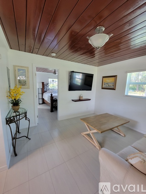 A living room with a wooden ceiling and a white couch.