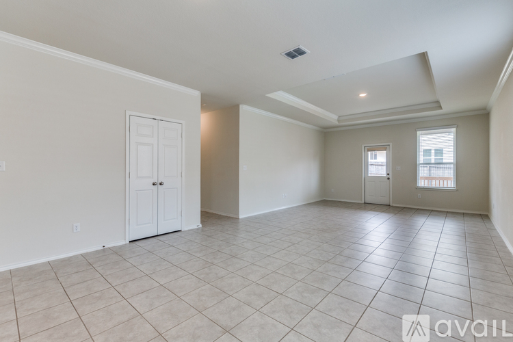 A spacious room with tiled flooring and two doors.