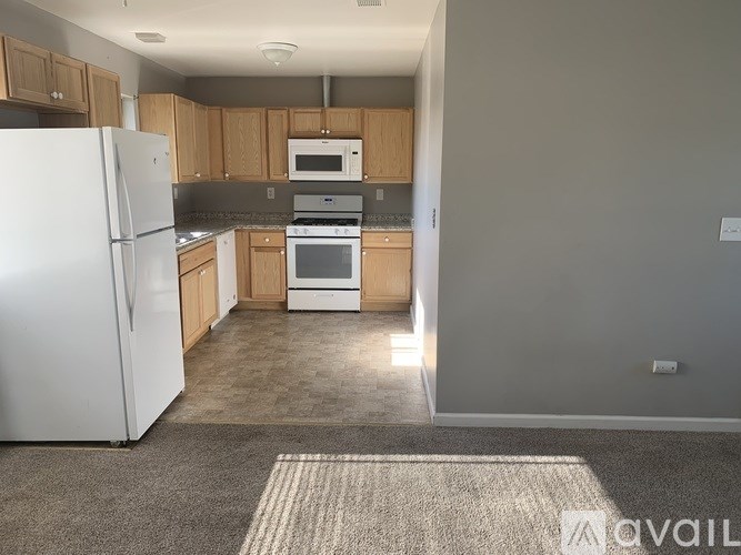 A kitchen with a white refrigerator, microwave, and oven.