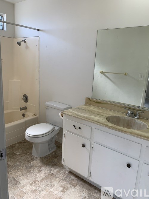 A bathroom with a toilet, sink, and bathtub.