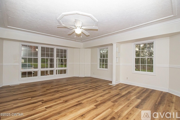 A room with wooden flooring and a ceiling fan.