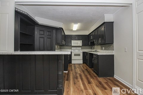 A kitchen with black cabinets and a white countertop.