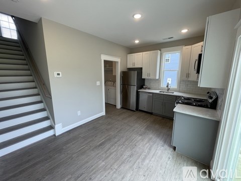 A kitchen with a refrigerator, sink, and cabinets.