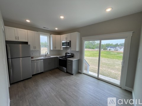 A kitchen with a refrigerator, sink, and stove is available for rent.