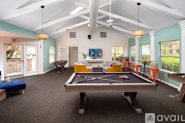 A room with a pool table and a TV.