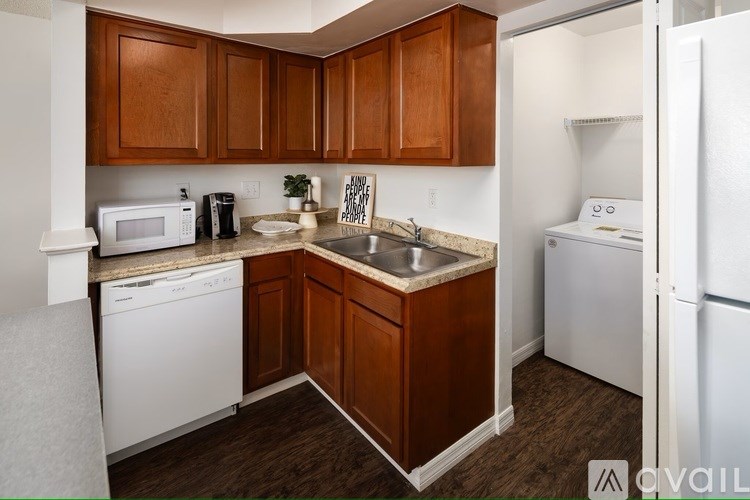 A kitchen with brown cabinets and white appliances.