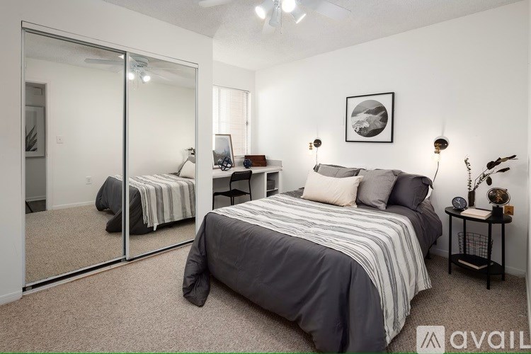 A bedroom with a large bed and a mirror on the wall.