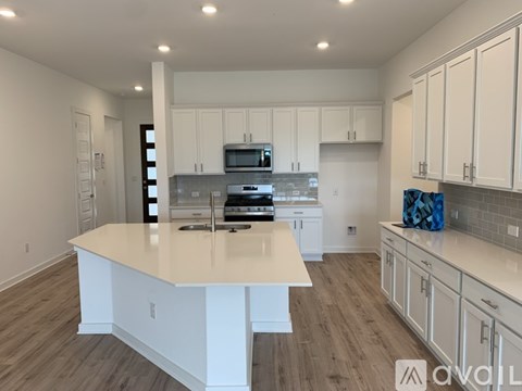 A kitchen with white cabinets and a large island.