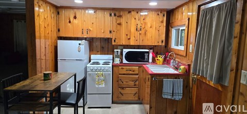 A kitchen with wooden cabinets and a white refrigerator.