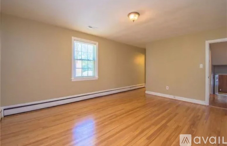 A room with wooden flooring and a window.