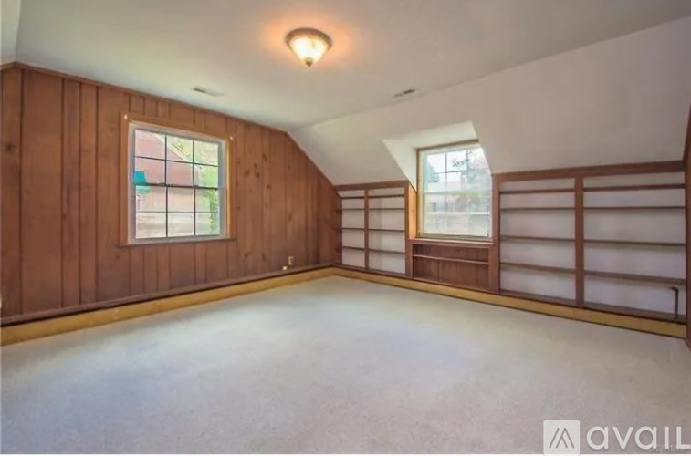 A room with wooden walls and a window with a view of a building.