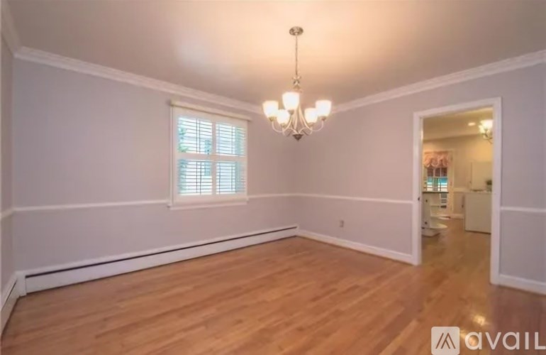A room with wooden floors and a chandelier.