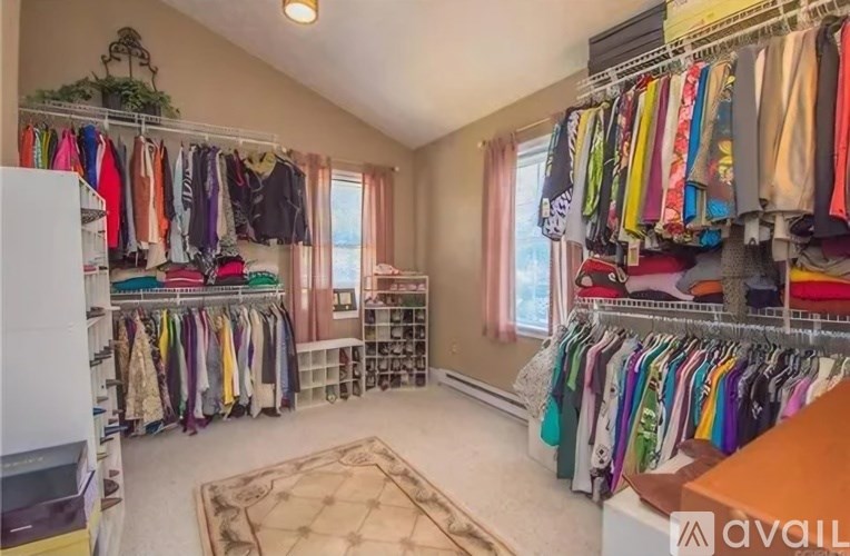 A spacious walk-in closet with clothes organized on shelves and hanging on racks.
