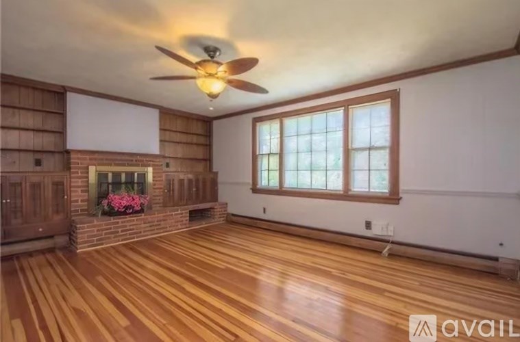 A room with wooden floors and a ceiling fan.