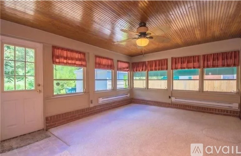 A room with a wooden ceiling and a fan in the middle.