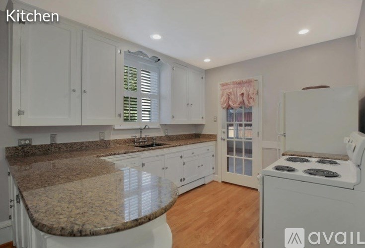 A kitchen with granite countertops and white cabinets.
