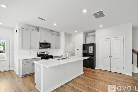 A modern kitchen with white cabinets and a large island.