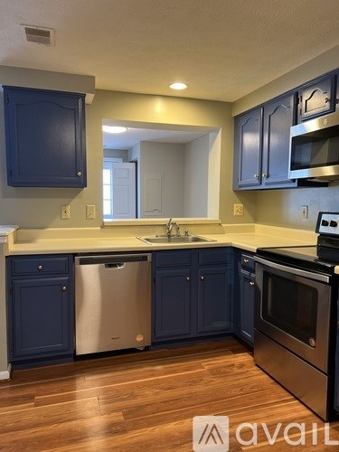 A kitchen with dark blue cabinets and stainless steel appliances.