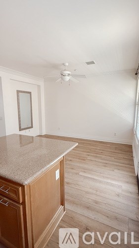 A kitchen with a counter and a fan.