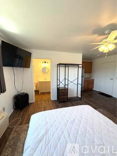 A bedroom with a bed, a television, and a sliding door.