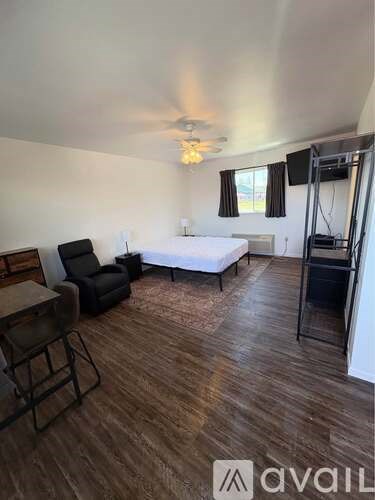 A room with a bed, a chair, and a table.