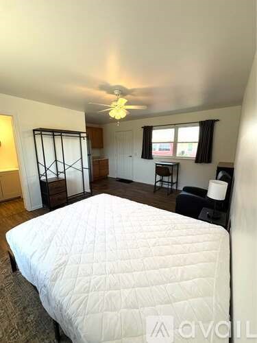 A bedroom with a large bed and a ceiling fan.