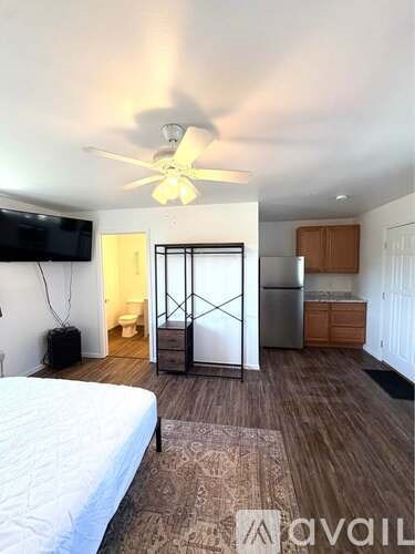 A bedroom with a bed, a television, and a sliding door leading to a bathroom.