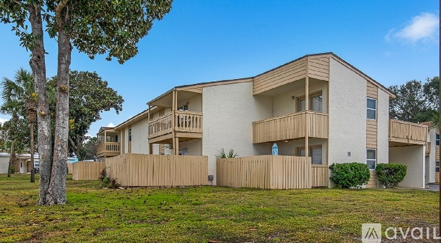 A modern two-story apartment building with a balcony on the second floor.