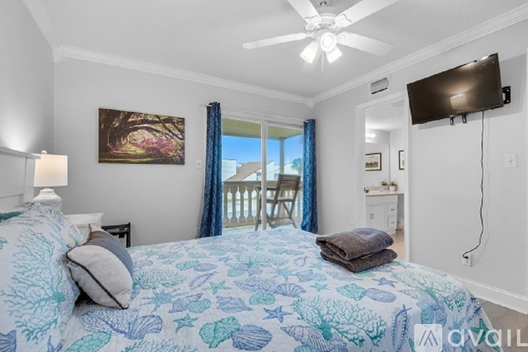 A bedroom with a large bed and a flat screen TV mounted on the wall.