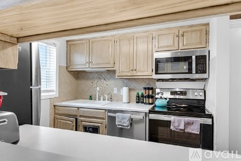 A kitchen with wooden cabinets and stainless steel appliances.