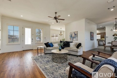 A living room with a white couch and a rug.
