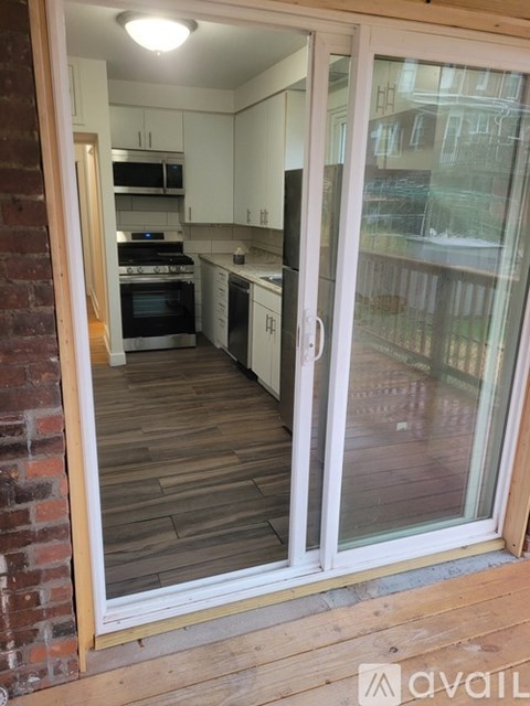 A kitchen with white cabinets and a brick wall.