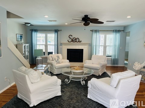 A living room with white furniture and a fireplace.