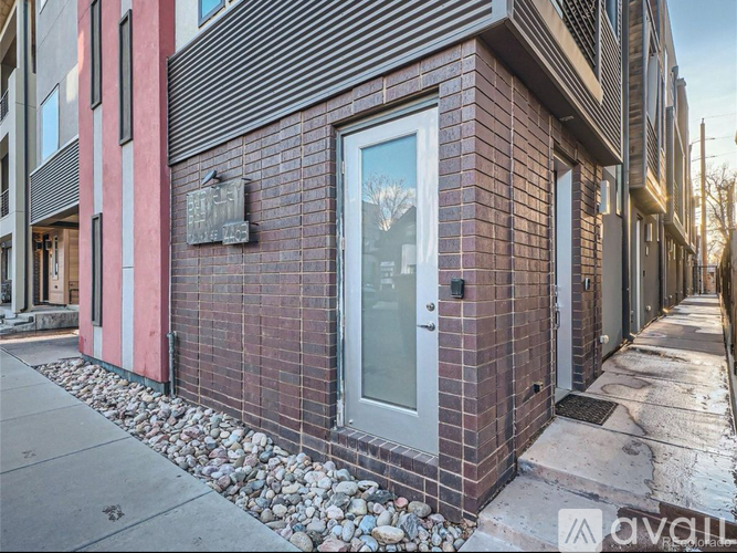 A red brick building with a glass door and a small plaque on the wall.