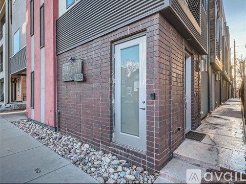 A red brick building with a glass door and a small plaque on the wall.