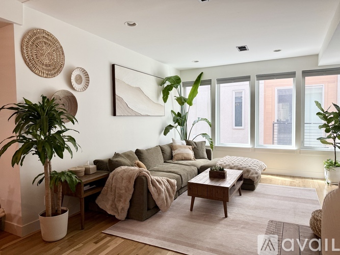 A living room with a couch, a coffee table, and a potted plant.