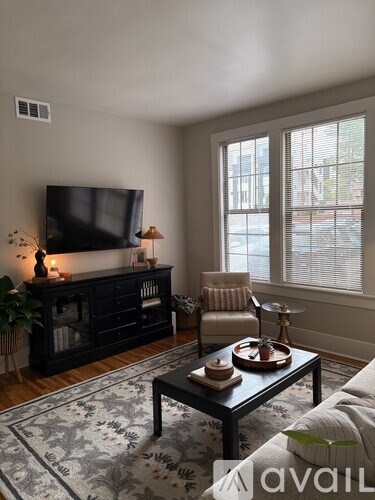 A living room with a television, chair, and a table with a tray on it.