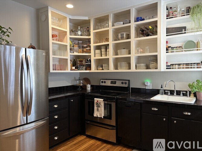 A kitchen with a refrigerator, oven, and sink.