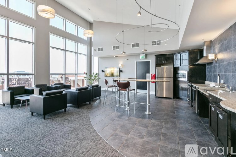 A modern open plan living and kitchen area with black furniture.