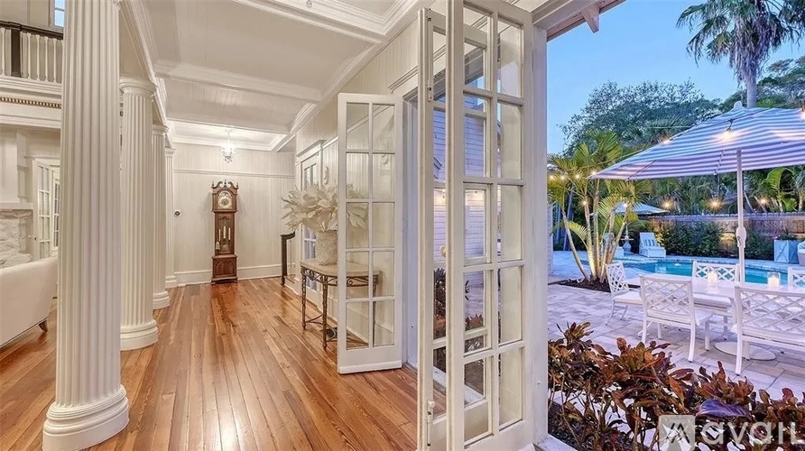 A white interior with a pool outside.