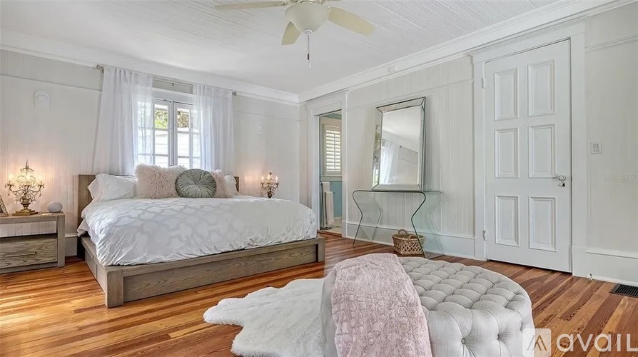 A bedroom with a large bed and a mirror on the wall.