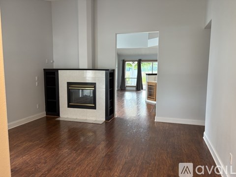 A living room with a fireplace and wood flooring.