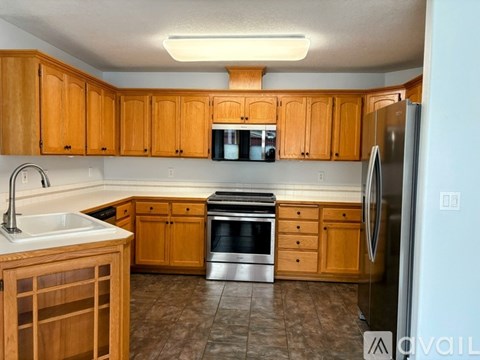 A kitchen with wooden cabinets and a white refrigerator.