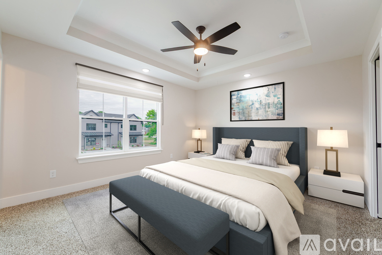 A bedroom with a large bed and a ceiling fan.
