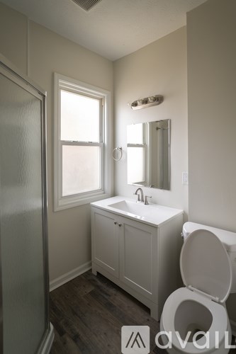 A bathroom with a toilet, sink, and mirror.