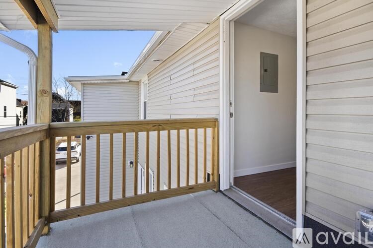 A balcony with a door leading to a room.