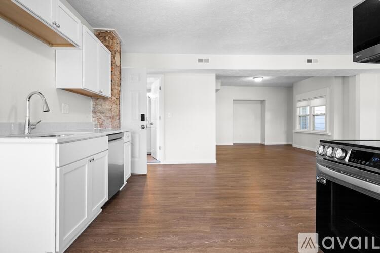 A kitchen with white cabinets and a black stove top oven.